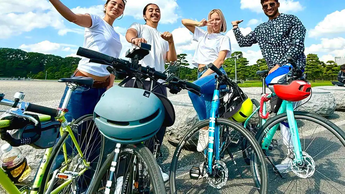 Cyclists riding past Shiba Park temple grounds on a guided e-bike tour of central Tokyo, Tokyo Japan