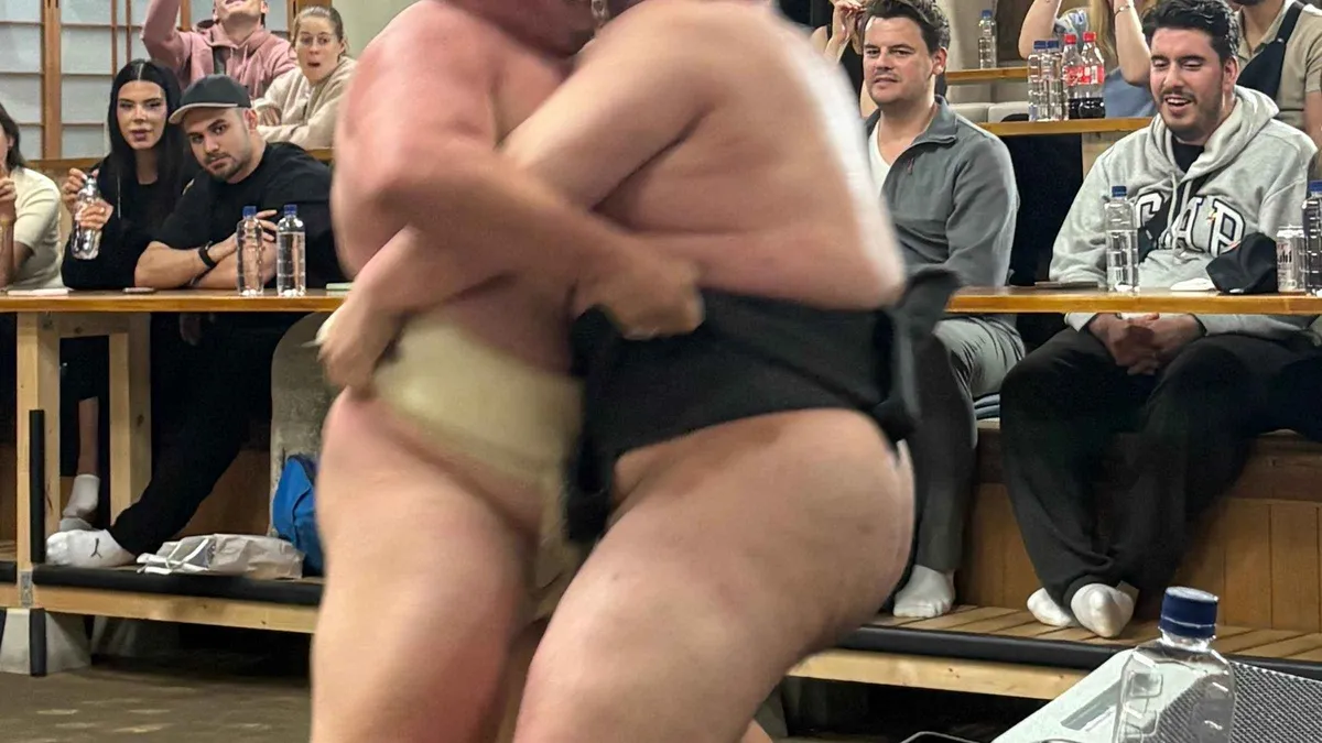 Retired sumo wrestlers demonstrating a match to visitors during a sumo show and dining experience in Tokyo