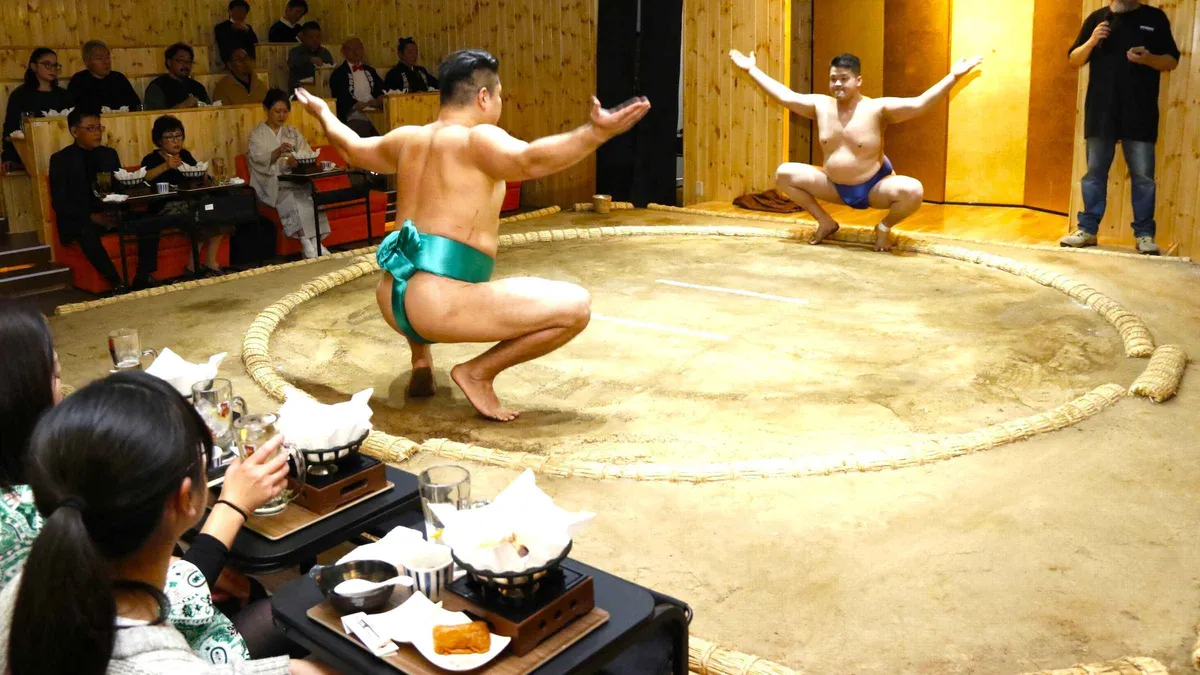 Retired sumo wrestlers facing off in the ring during a Tokyo sumo show with chanko hot pot, Asakusa Tokyo