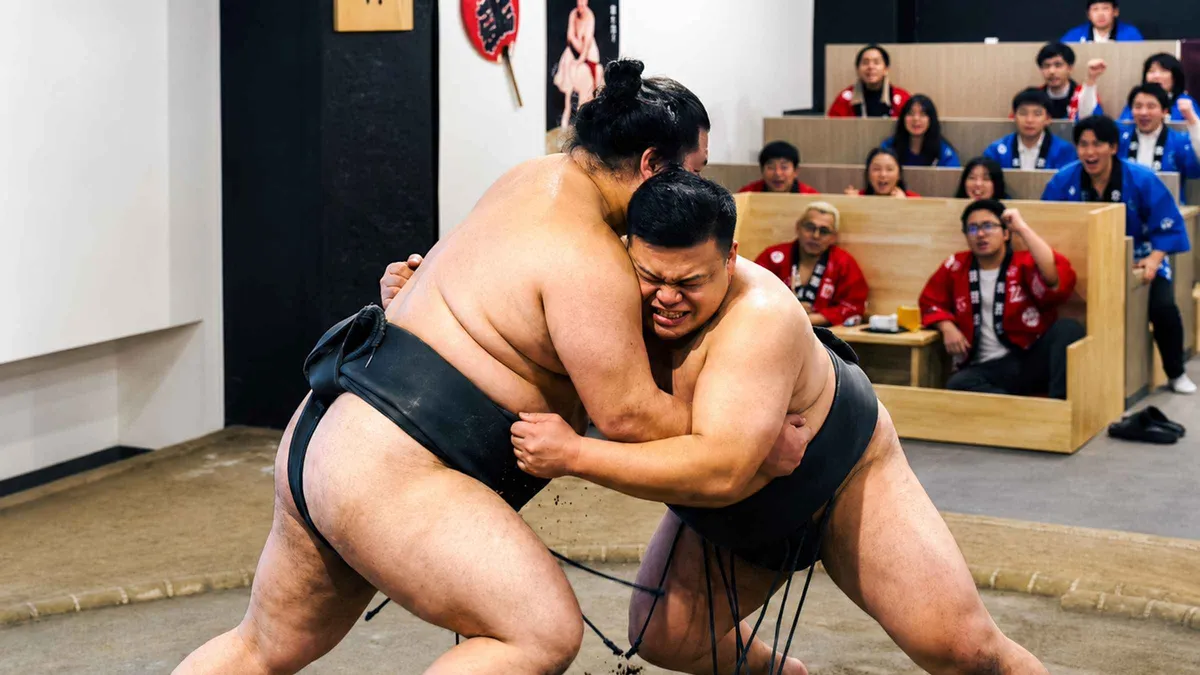 Retired wrestlers performing ceremonial sumo movements on stage during a Tokyo Ginza sumo show, Tokyo Japan